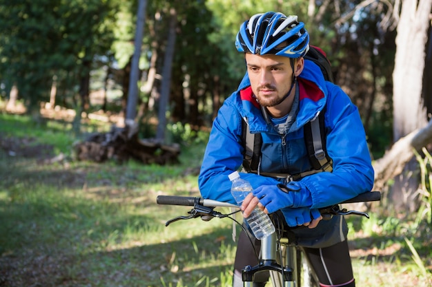 ciclista in mountain-bike maschio che sta con la bicicletta