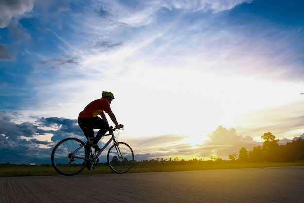 Ciclista in movimento sullo sfondo bel tramonto con silhouette.Ciclista nel concetto di estate