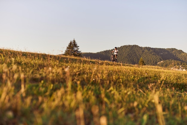 Ciclista in sella alla bici sul sentiero nella foresta Uomo in bicicletta su pista da enduro motivazione e ispirazione per il fitness sportivo Extreme Sport Concept Focus selettivo