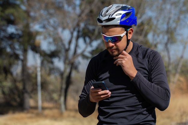 Ciclista messicano guardando il suo cellulare GPS