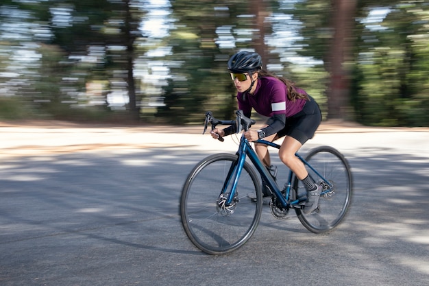 Ciclista professionista ad alta velocità su strada con la sua bici da pista Triathlon concept