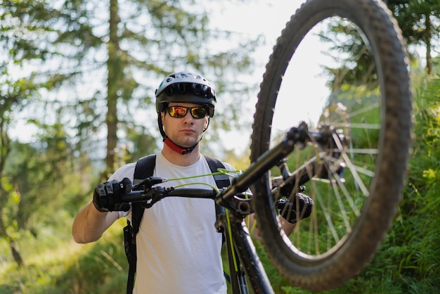 Ciclista professionista di mountain bike in sella a un sentiero nella foresta Sport d'avventura estremo all'aperto