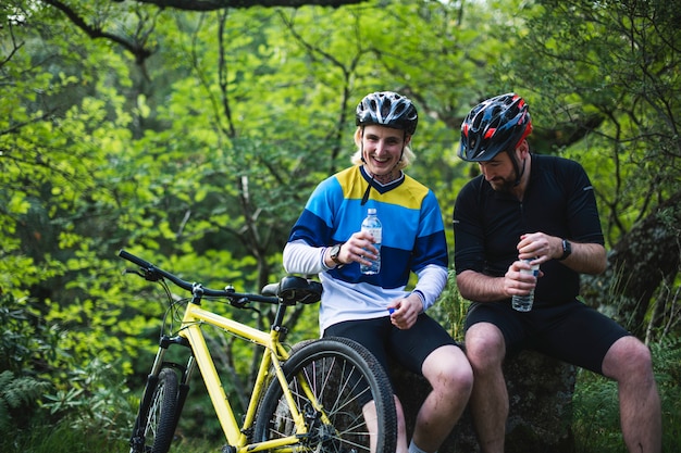 Ciclista riposo e acqua potabile nella foresta