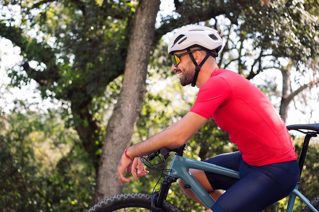 Ciclista sorridente che riposa sulla sua bici dopo l'allenamento