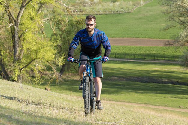 Ciclista su prati verdi in una serata estiva bellissimo paesaggio