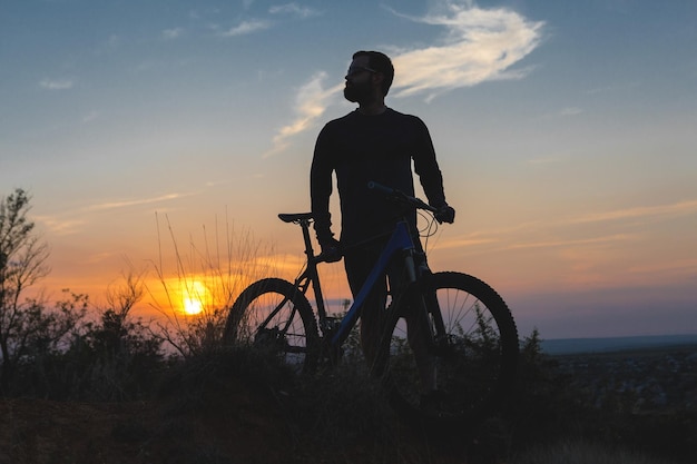 Ciclista su prati verdi in una serata estiva bellissimo paesaggio