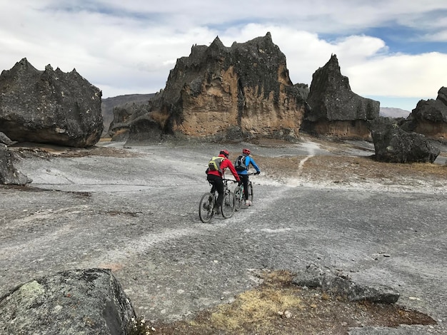 Ciclistas conduciendo por un camino tra rocce giganti