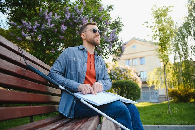 Cieco libro di lettura sulla panchina nel parco