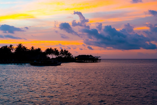 Cielo al tramonto con l'isola delle Maldive