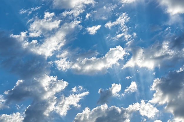 Cielo azzurro con nuvole e raggi di luce in estate