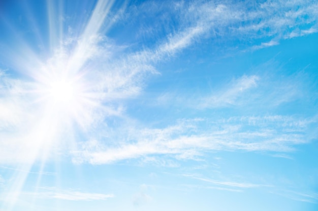 Cielo azzurro con nuvole leggere e raggi di sole