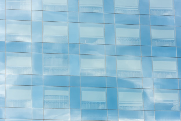 Cielo azzurro e nuvole riflesse nelle finestre di un moderno edificio per uffici