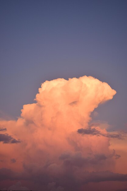 Cielo azzurro e una grande nuvola con i colori del tramonto