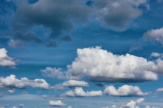 Cielo azzurro nuvoloso con nuvole diverse e una grande nuvola bianca in primo piano