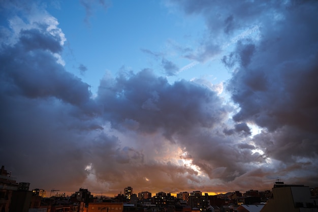 Cielo blu al crepuscolo del tramonto sopra le luci della città con nuvole pesanti