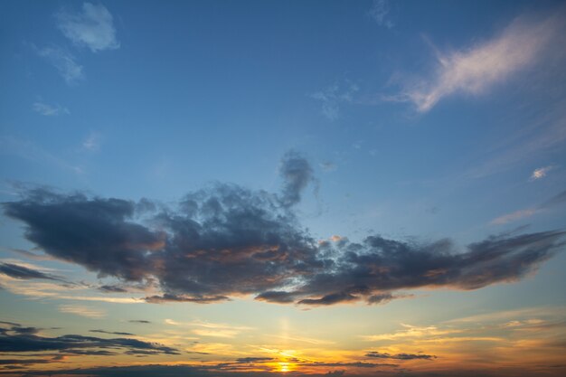 Cielo blu al tramonto coperto di nuvole gonfie bianche.