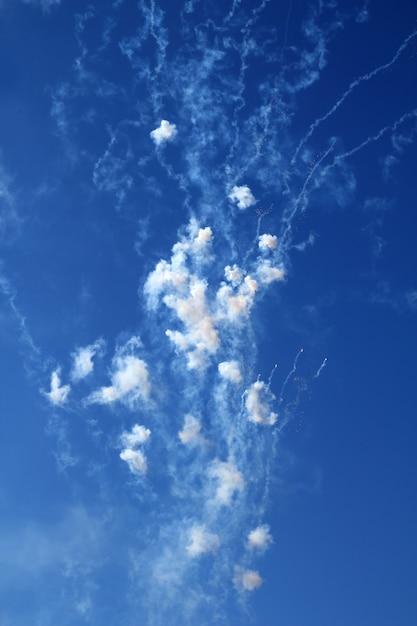 Cielo blu con le nuvole bianche dei petardi dei fuochi d&#39;artificio