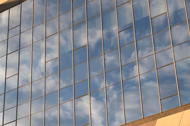 Cielo blu con nuvole bianche che si riflettono sulla facciata del business center