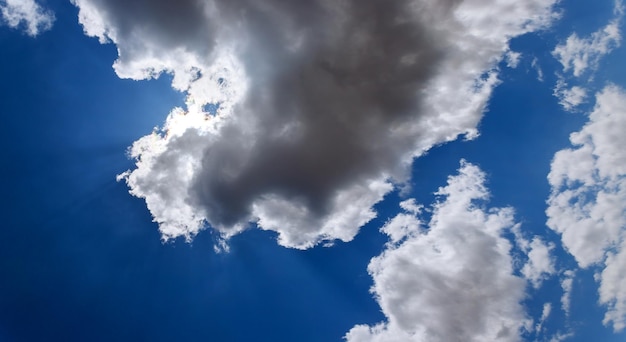 Cielo blu con nuvole e sfondo del sole con minuscolo con il primo piano della nuvola