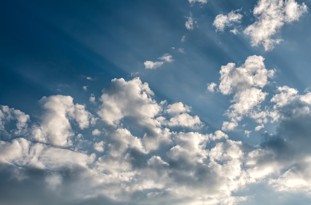 Cielo blu con soffici nuvole bianche e raggi di sole