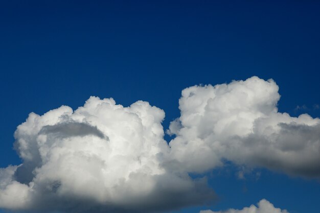 Cielo blu scuro con grandi nuvole bianche luminose. avvicinamento