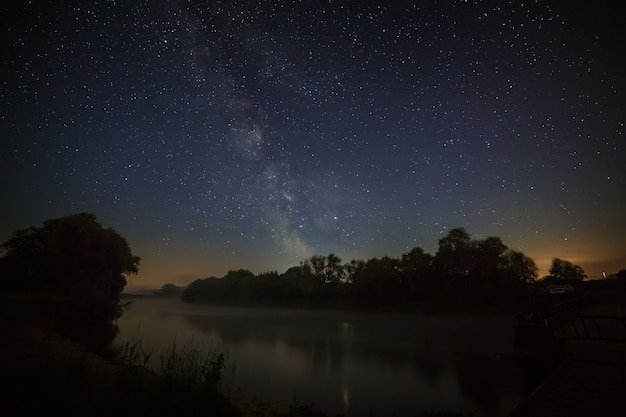 Cielo notturno stellato con la Via Lattea sul fiume.