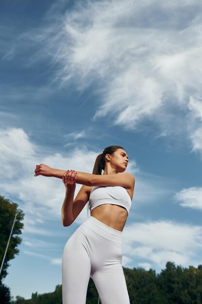 Cielo nuvoloso Giovane donna in abiti sportivi si esercita all'aperto