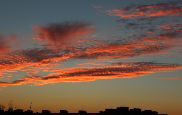 Cielo nuvoloso rosso sopra il paesaggio urbano al tramonto