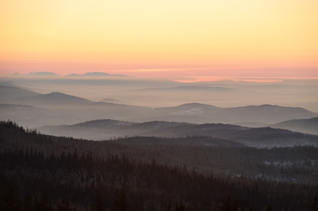 Cielo rosa e giallo e montagne ricoperte di foresta