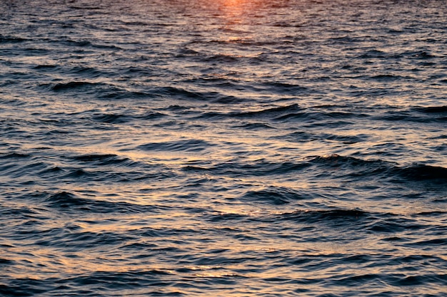 Cielo rosso brillante drammatico al tramonto sull'oceano nuvole morbide serali sull'acqua scura del mare