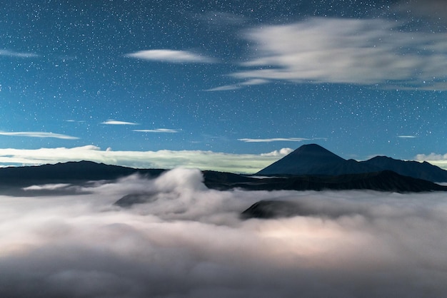 Cielo stellato nel paesaggio con vulcani tra le nuvole Volcano Bromo National Park