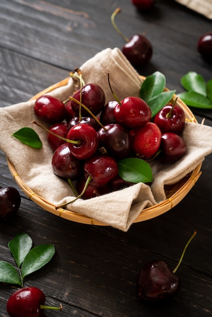 Ciliege fresche in ciotola sulla tavola di legno