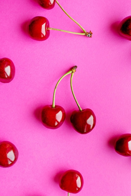 Ciliege mature su una foto verticale di sfondo rosa