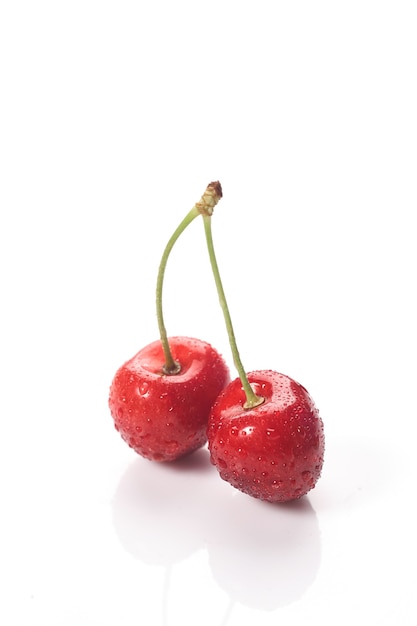 Ciliegie rosse con gocce d'acqua, primo piano. Isolato su sfondo bianco.