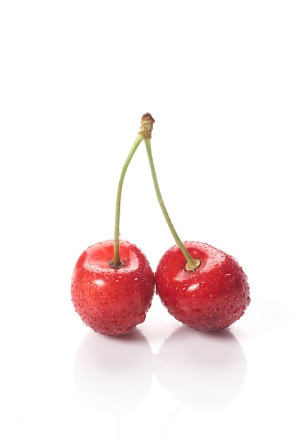 Ciliegie rosse con gocce d'acqua, primo piano. Isolato su sfondo bianco.