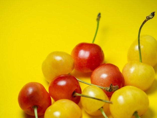 Ciliegio dolce con un gambo su sfondo giallo Tavolo luminoso Bacche naturali sul tavolo