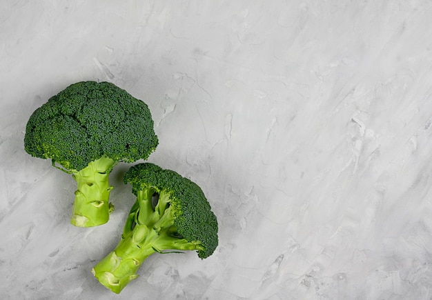 Cimette di broccoli crudi organici verdi sani sulla tavola grigia