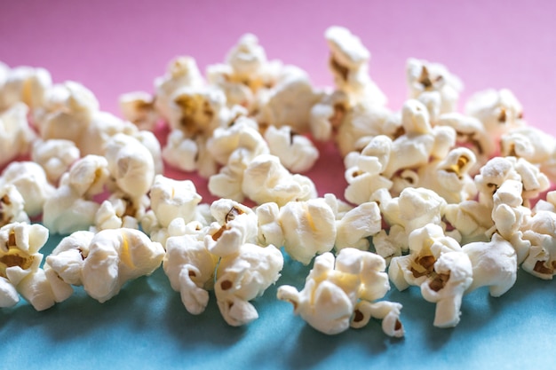 Cinema popcorn su sfondo pastello pastello e blu rosa. Spuntino di film