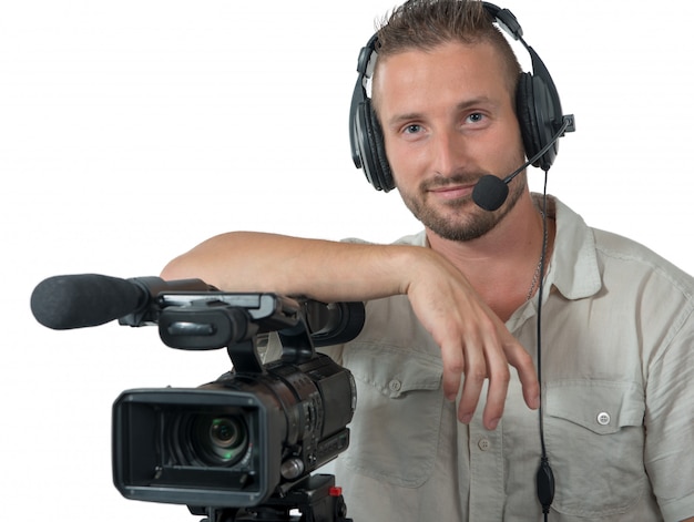 Cineoperatore con la videocamera portatile e la cuffia professionali isolate su bianco