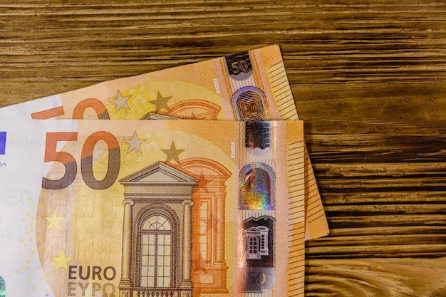 Cinquanta banconote in euro su fondo di legno rustico