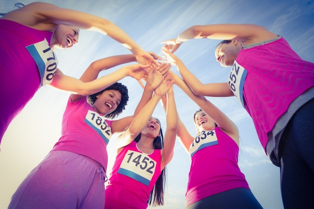 Cinque corridori incoraggianti che sostengono la maratona del cancro al seno