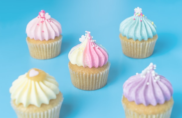 Cinque mini cupcake su sfondo blu pastello