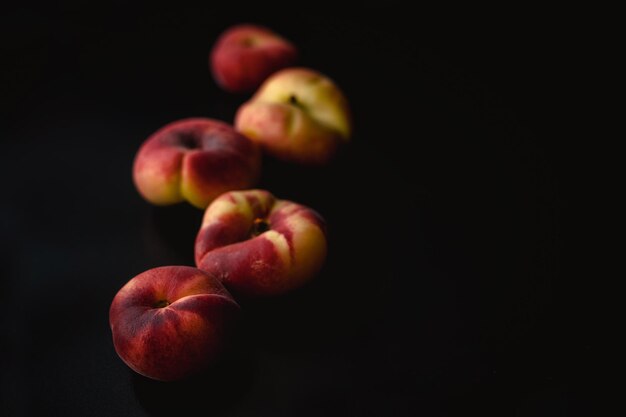 Cinque nettarine di fichi in prospettiva su sfondo nero