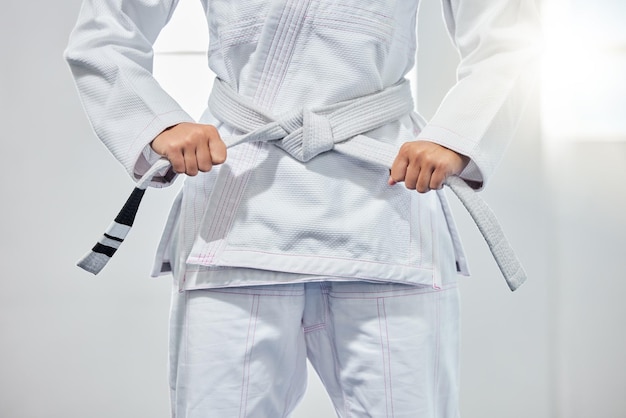 Cintura di karate arti marziali e donna pronta per combattere battaglia allenamento dojo bianco o allenamento sfida fitness Motivazione del guerriero taekwondo e mani della ragazza che imparano l'autodifesa per la sicurezza sicurezza