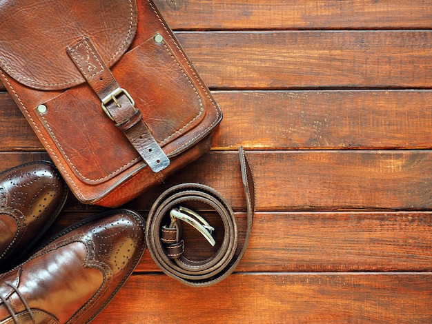 Cintura valigetta in pelle e scarpe da uomo su fondo in legno