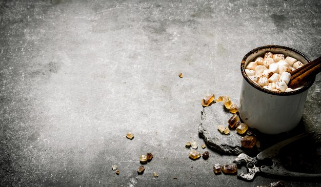 Cioccolata calda con cannella e zucchero fondente. Su uno sfondo di pietra.