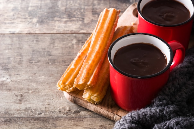 Cioccolata calda con churros sul tavolo di legno Copia spazio