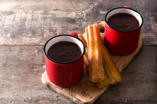 Cioccolata calda con churros sul tavolo di legno