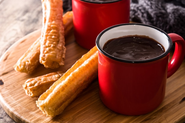 Cioccolata calda con churros sulla fine di legno della tavola su