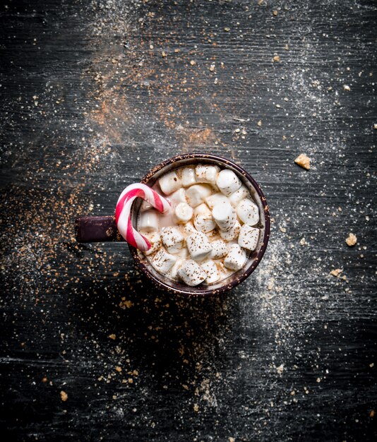 Cioccolata calda con marshmallow e caramello. Su una lavagna nera.